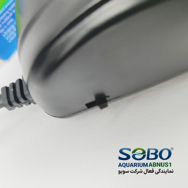 پمپ هوای آکواریوم SOBO SB-8802 تک‌خروجی با طراحی مشکی، بی‌صدا و دارای دکمه تنظیم میزان هوادهی.تصاویر محصول شامل نمای جلو، نمای جانبی با دکمه تنظیم، و نمای نصب شده داخل آکواریوم.مناسب آکواریوم‌های خانگی و گیاهی که نیاز به تامین هوای پایدار با کم‌ترین صدا دارند.