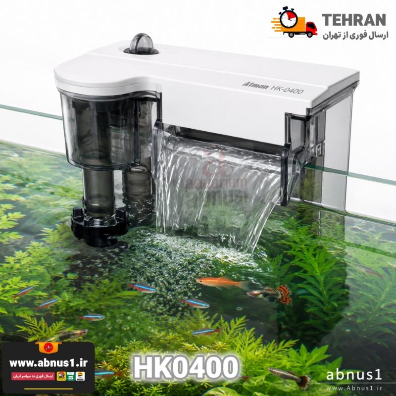 فیلتراسیون آکواریوم بلک هنگان HK-0400 برند ATMAN فیلتر آویزان (Hang-On) برند معتبر “Atman” مدل HK-0400 است. در نمای روی جعبه، بزرگترین سایز این سری از فیلترها با بدنه شفاف و مستحکم به تصویر کشیده شده است. طراحی دستگاه به گونهای است که بر روی لبه آکواریوم قرار میگیرد و فضای داخلی را اشغال نمیکند. در عکس، لوله مکش بلندتر مجهز به چربیگیر سطح (Skimmer) و پیچ تنظیم جریان خودنمایی میکند. همچنین به ویژگی “Super Fit” (نصب بسیار محکم) روی جعبه اشاره شده که نشاندهنده پایداری بالای این مدل بر روی شیشههای مختلف است. خروجی آبشاری پهن در تصویر، گویای قدرت بالای گردش آب و اکسیژنرسانی حداکثری این دستگاه میباشد.